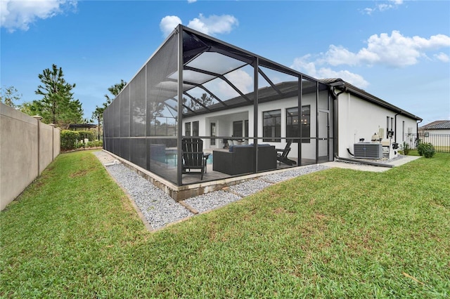 rear view of property featuring a yard, a patio, a lanai, and a fenced backyard