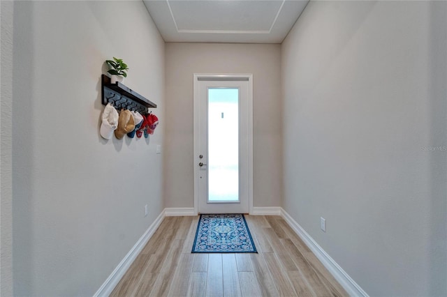 doorway to outside featuring light wood finished floors and baseboards