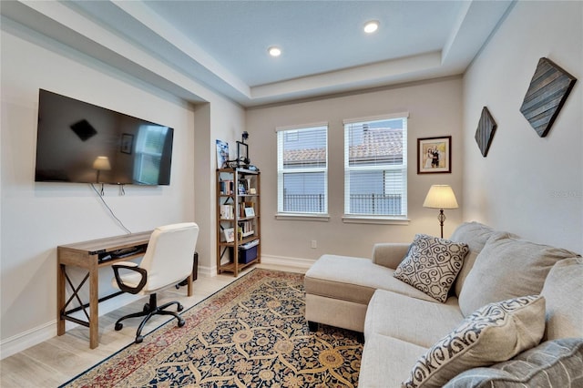 home office featuring a raised ceiling, recessed lighting, wood finished floors, and baseboards