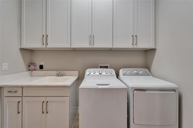 laundry room with washer and dryer, cabinet space, and a sink