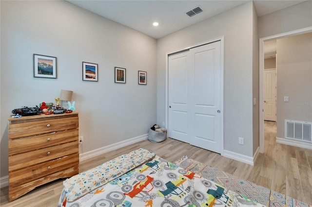 bedroom with light wood-type flooring and visible vents