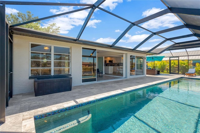 pool with glass enclosure and a patio area