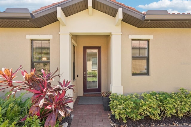 doorway to property featuring stucco siding