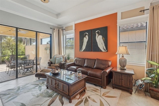 living room with a tray ceiling and tile patterned floors