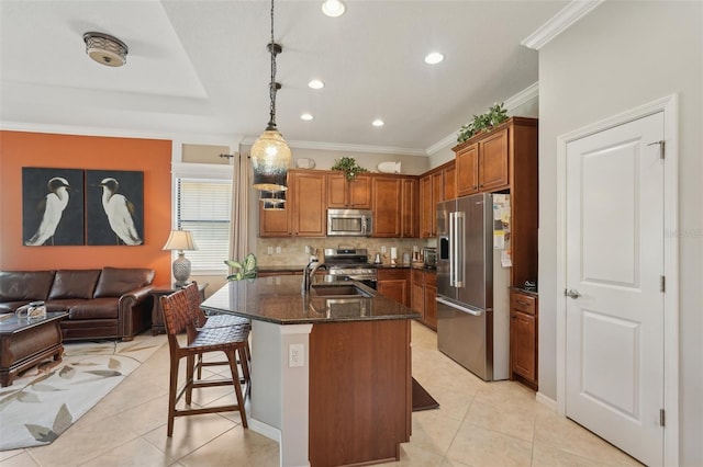 kitchen featuring light tile patterned flooring, appliances with stainless steel finishes, dark stone countertops, and brown cabinets