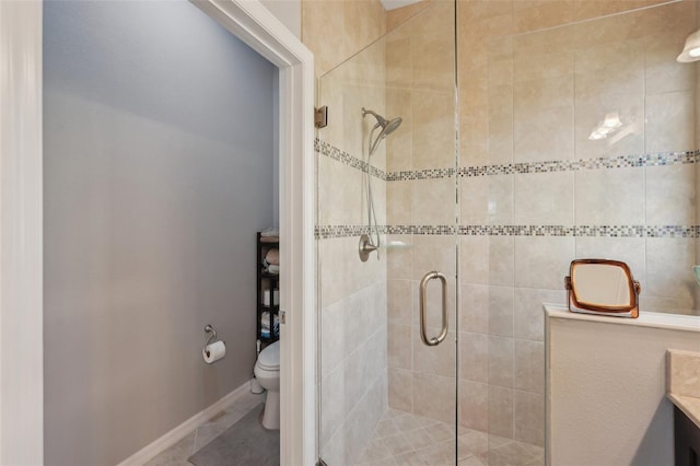 bathroom featuring a shower stall, baseboards, toilet, and vanity