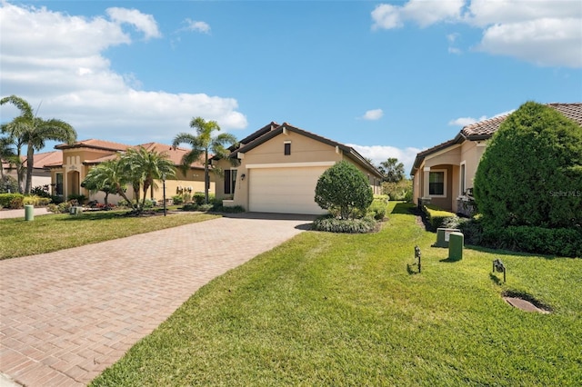 mediterranean / spanish house featuring stucco siding, an attached garage, a tiled roof, decorative driveway, and a front yard