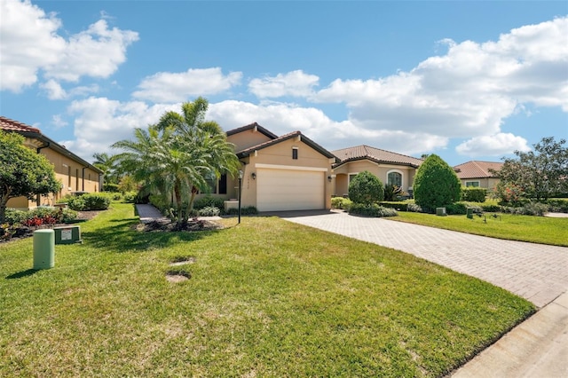 mediterranean / spanish-style house featuring a front yard, decorative driveway, stucco siding, and an attached garage