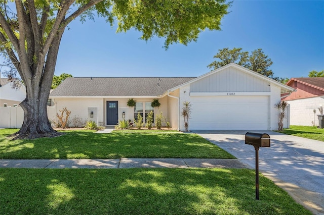 view of front of property with brick siding, a front lawn, fence, concrete driveway, and an attached garage