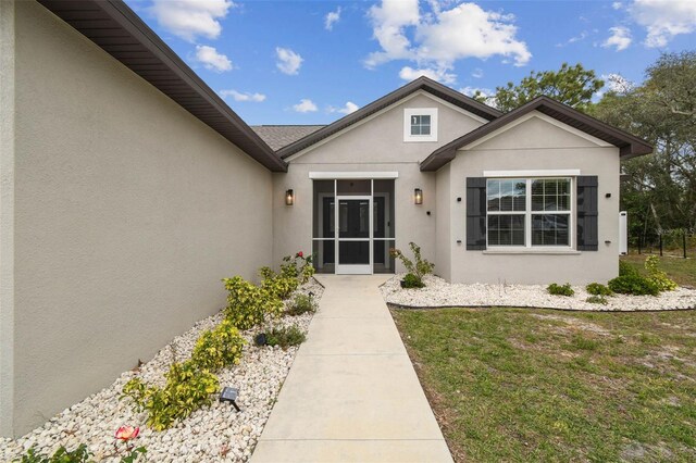 4307 Dristol Ave, Spring Hill, FL 34609 - property entrance featuring stucco siding and a lawn