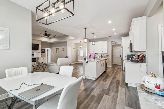 4307 Dristol Ave, Spring Hill, FL 34609 - dining space with a tray ceiling, dark wood finished floors, baseboards, ceiling fan with notable chandelier, and recessed lighting
