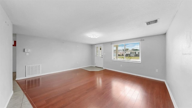 empty room featuring baseboards, visible vents, and light wood-type flooring