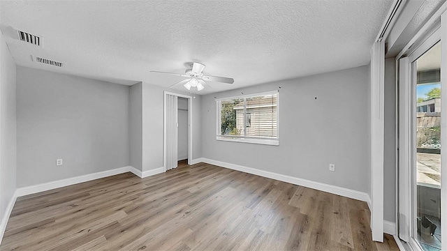 unfurnished bedroom featuring a closet, visible vents, baseboards, and wood finished floors