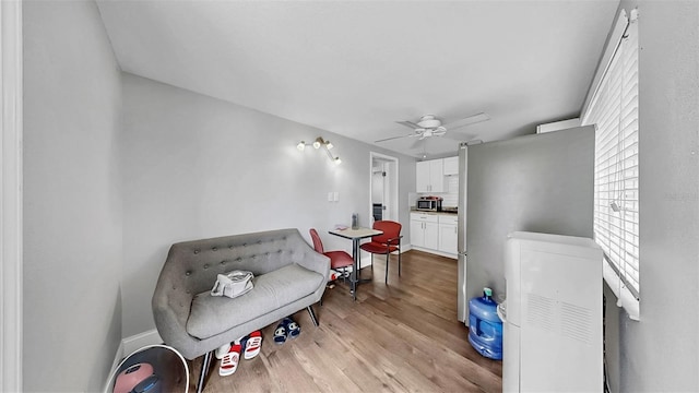 living area with light wood finished floors and ceiling fan