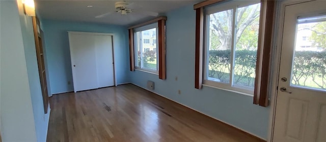 2402 Ecuadorian Way Unit 20, Clearwater, FL 33763 - unfurnished bedroom featuring wood finished floors, multiple windows, and a closet