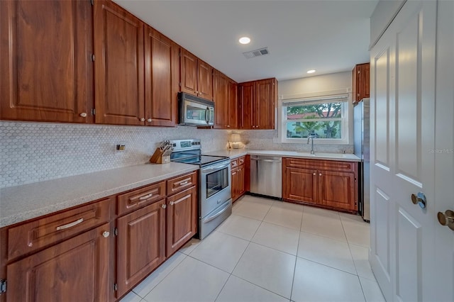 2700 Bayshore Blvd Unit 588, Dunedin, FL 34698 - kitchen featuring stainless steel appliances, decorative backsplash, light countertops, brown cabinetry, and recessed lighting
