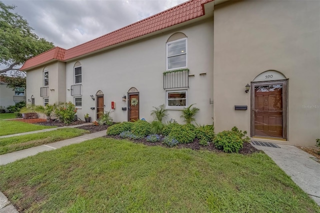 2700 Bayshore Blvd Unit 588, Dunedin, FL 34698 - view of front of house with a tile roof, a front lawn, and stucco siding