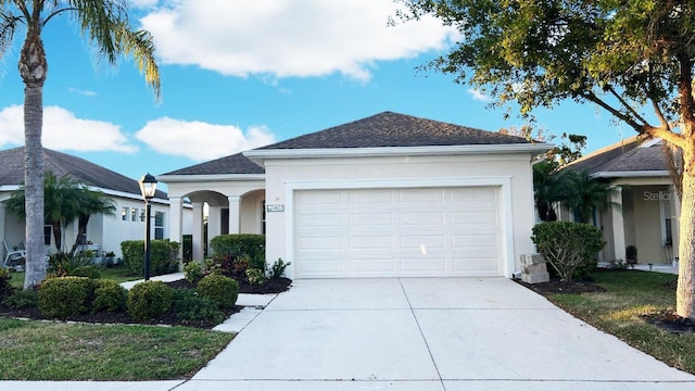 11822 Crawford Parrish Ln, Parrish, FL 34219 - ranch-style house featuring concrete driveway, stucco siding, a garage, and roof with shingles