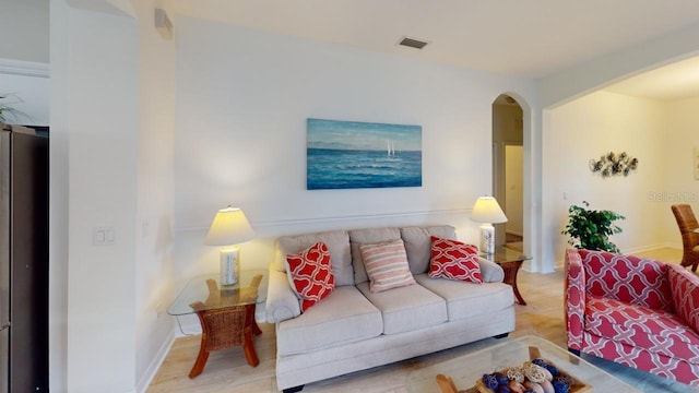 11822 Crawford Parrish Ln, Parrish, FL 34219 - living room featuring arched walkways, baseboards, and wood finished floors