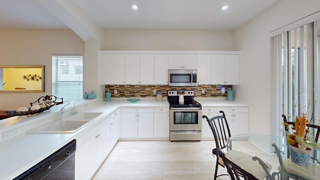 11822 Crawford Parrish Ln, Parrish, FL 34219 - kitchen with appliances with stainless steel finishes, a sink, decorative backsplash, recessed lighting, and white cabinetry