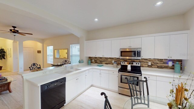 11822 Crawford Parrish Ln, Parrish, FL 34219 - kitchen with appliances with stainless steel finishes, arched walkways, a sink, tasteful backsplash, and recessed lighting