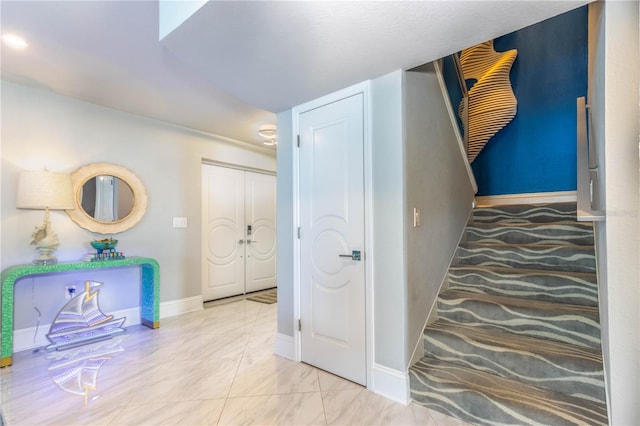corridor with baseboards and marble look tiles