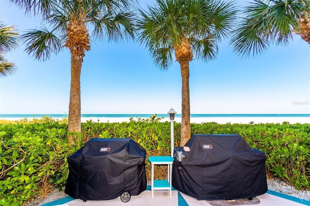 view of patio with grilling area and view of water and beach
