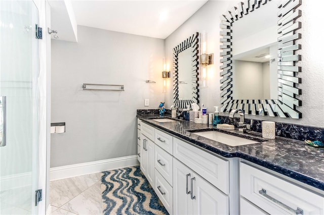full bathroom featuring marble finish flooring, double vanity, and baseboards