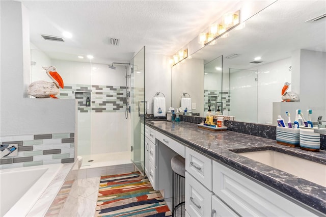 full bathroom with a bath, a shower stall, double vanity, a textured ceiling, and tile patterned flooring