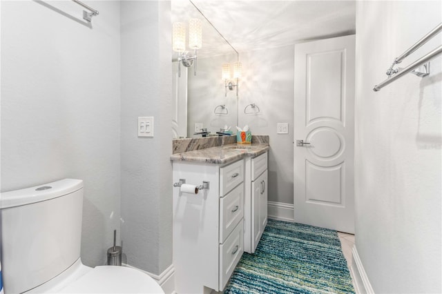 bathroom with toilet, vanity, and tile patterned flooring