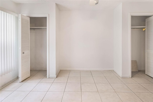 19029 US Highway 19 N Unit 2-12, Clearwater, FL 33764 - unfurnished bedroom with light tile patterned flooring, baseboards, and a closet