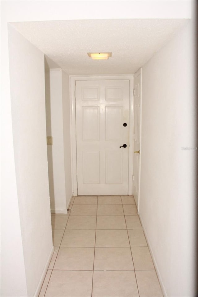 19029 US Highway 19 N Unit 2-12, Clearwater, FL 33764 - hall with light tile patterned flooring, baseboards, and a textured ceiling