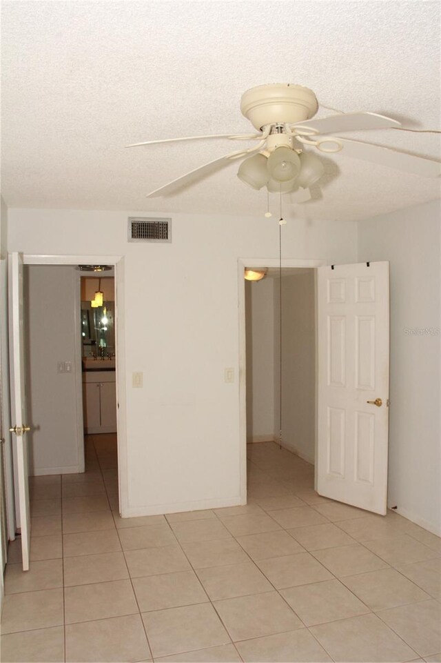19029 US Highway 19 N Unit 2-12, Clearwater, FL 33764 - spare room featuring light tile patterned flooring, a ceiling fan, and a textured ceiling