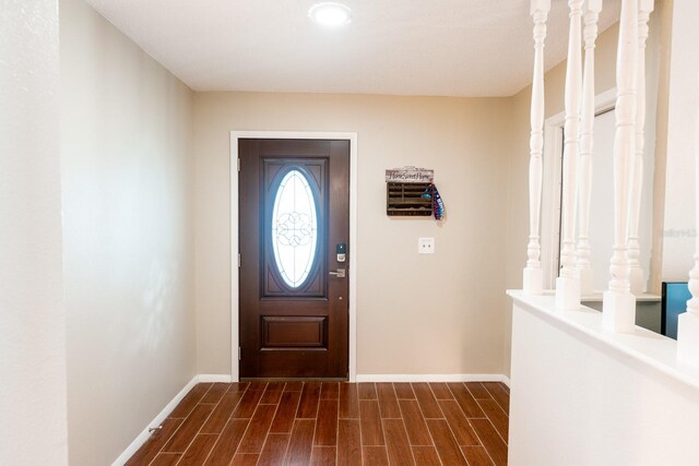 entrance foyer with baseboards and wood finish floors