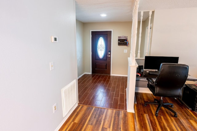 entryway featuring visible vents, baseboards, and wood finished floors