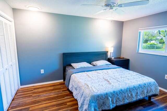 bedroom with ceiling fan, a textured ceiling, baseboards, and wood finished floors