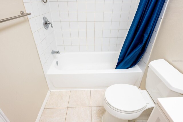 bathroom featuring tile patterned floors, shower / bath combination with curtain, toilet, and baseboards