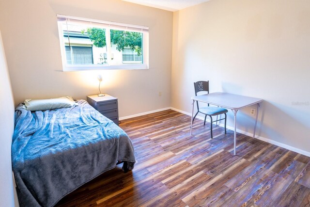 bedroom with baseboards and wood finished floors