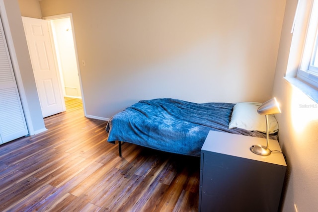 bedroom with wood finished floors and baseboards