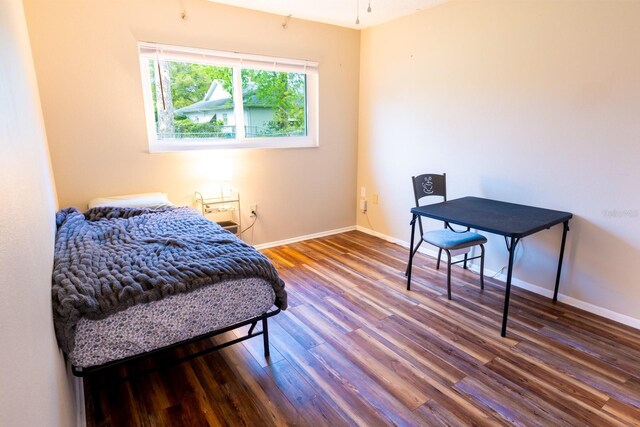 bedroom with wood finished floors and baseboards