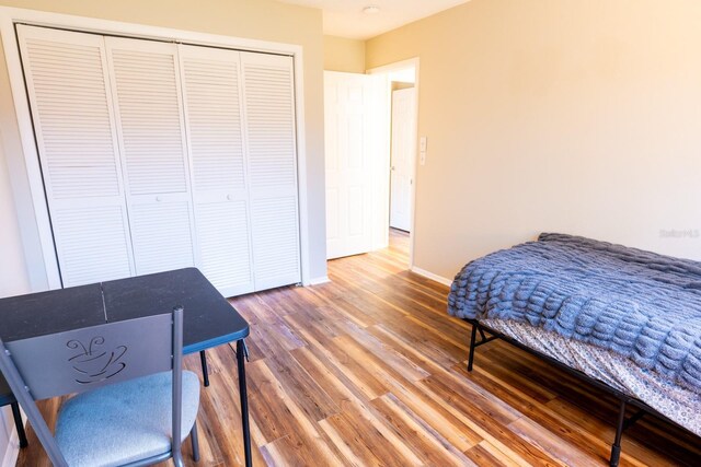 bedroom with a closet, baseboards, and wood finished floors