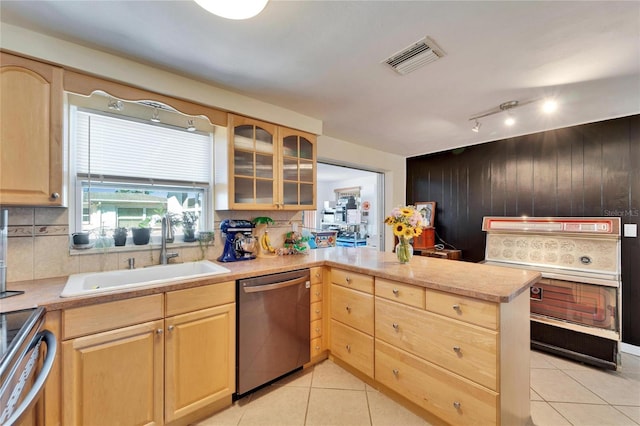 2533 Limewood Dr, Holiday, FL 34690 - kitchen featuring stainless steel appliances, light brown cabinets, a peninsula, backsplash, and wooden walls