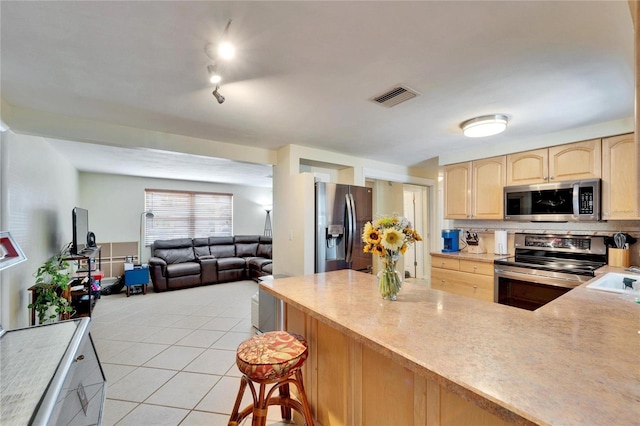 2533 Limewood Dr, Holiday, FL 34690 - kitchen with appliances with stainless steel finishes, light brown cabinets, light tile patterned floors, and light countertops