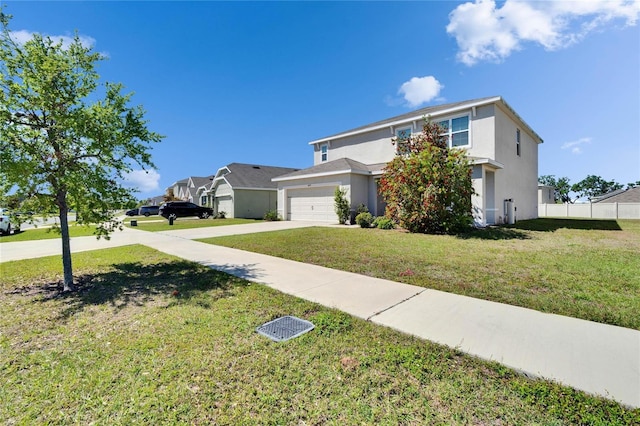traditional-style home featuring concrete driveway, a front yard, fence, and stucco siding