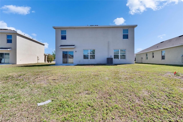 back of house with a yard, stucco siding, and central air condition unit