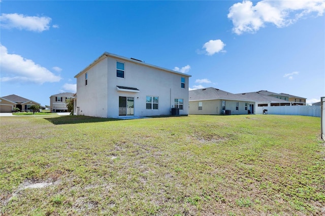 rear view of property featuring stucco siding and a lawn