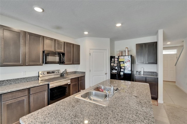 kitchen featuring recessed lighting, light tile patterned floors, dark brown cabinets, black appliances, and a sink