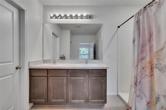 bathroom featuring double vanity, a shower with curtain, a sink, and tile patterned flooring