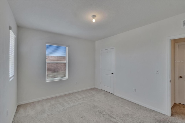 unfurnished room featuring light carpet, baseboards, and visible vents