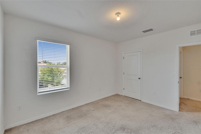 empty room with baseboards, carpet, and visible vents
